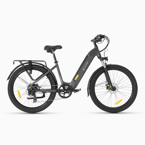 Grijze DYU C1 e-bike met voorvorkvering naast een strand, perfect voor stadsritten.